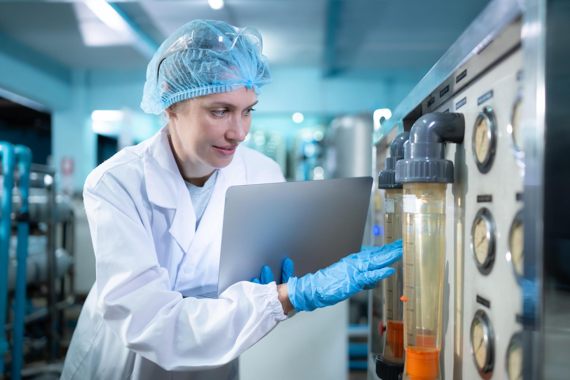 Eine Umwelttechnologin für Wasserversorgung prüft die Wasserqualität an einer Maschine mit verschiedenen Zeigern.