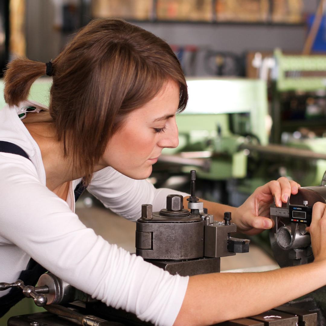 Eine Frau misst an einer Maschine etwas aus.